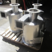 Stainless steel cyclone dust collectors resting on wooden pallets for transport. Stainless steel cyclone dust collectors resting on wooden pallets for transport.