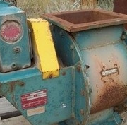 Used and weathered industrial rotary airlock valve with visible surface rust.